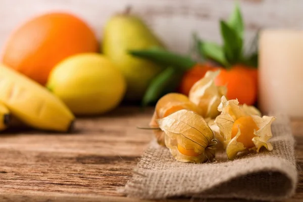 Fruta de groselha espinhosa em tecido de juta com outras frutas no fundo — Fotografia de Stock