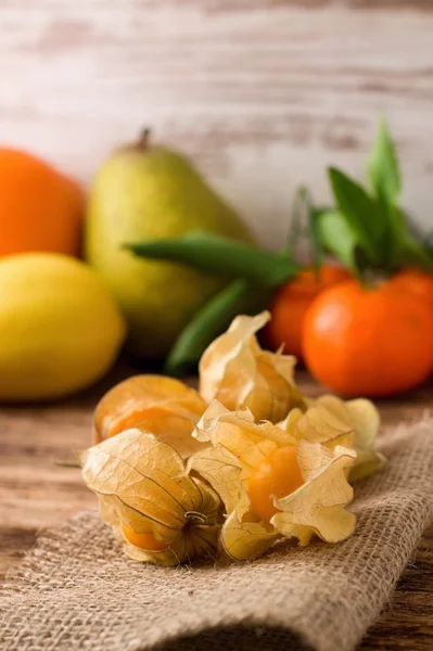 Fruta de groselha espinhosa em tecido de juta com outras frutas no fundo — Fotografia de Stock