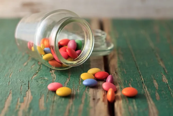 Yeşil ahşap tahta üzerinde dökülmüş çikolata smarties