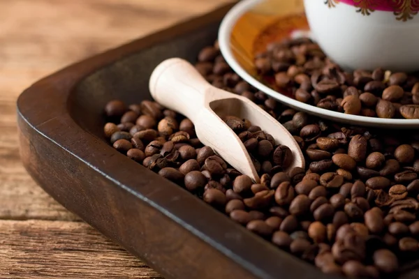 Koffie korrels op dienblad van donker hout — Stockfoto