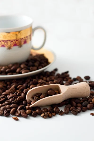 Grains de café, cuillère en bois et tasse blanche — Photo