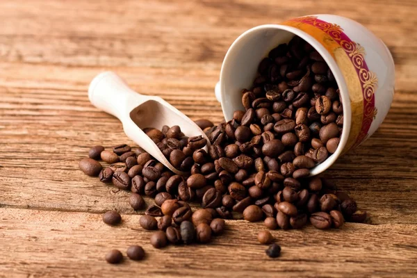 Gemorste kopje koffie korrels op een houten bord vol — Stockfoto