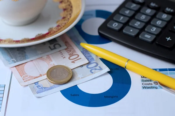 Uma moeda de euro, notas, calculadora e caneta — Fotografia de Stock