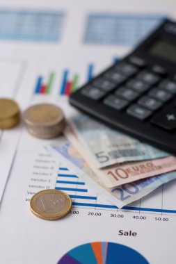 Bir hesap makinesi yakınındaki kağıt üzerine pirinç madeni para