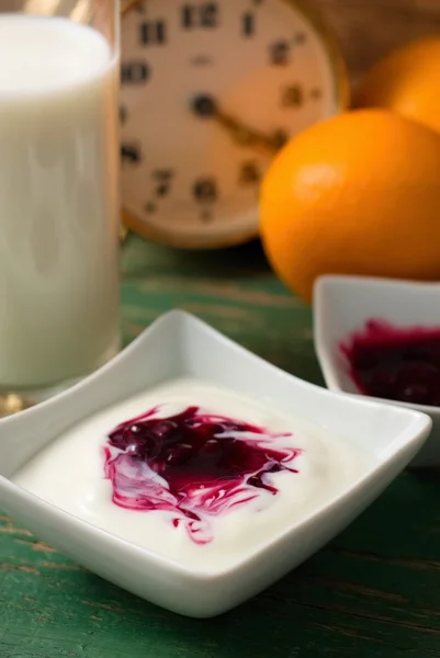 Mixed fruit in white yogurt on green worn table — Stock Photo, Image