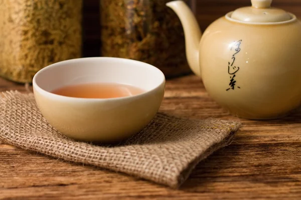 Tè cinese in tazza con bollitore a destra — Foto Stock