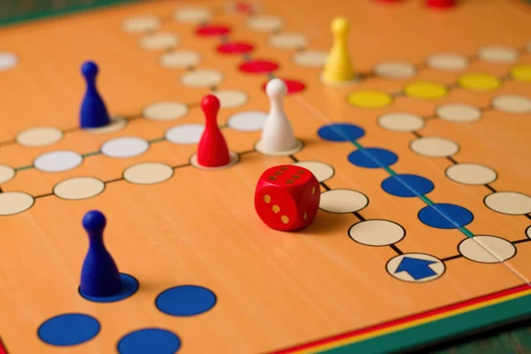 Würfel mit sechs nach oben zwischen Figuren auf ludo — Stockfoto