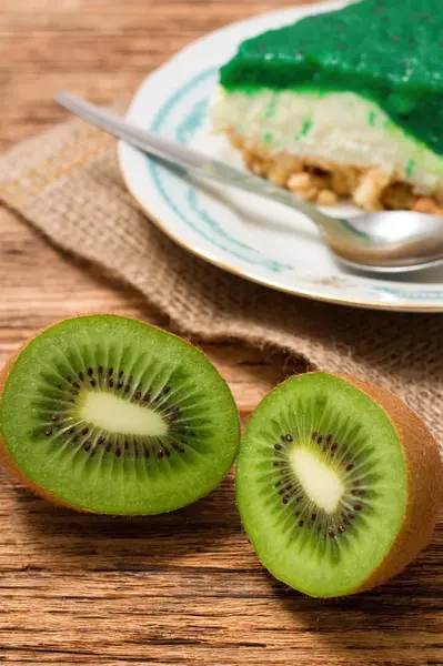 Două jumătăți de fructe Kiwi în fața tortului verde — Fotografie, imagine de stoc