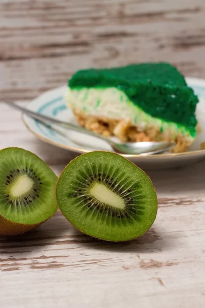 Kiwi fructe tăiate în jumătate în fața feliei verzi de tort — Fotografie, imagine de stoc