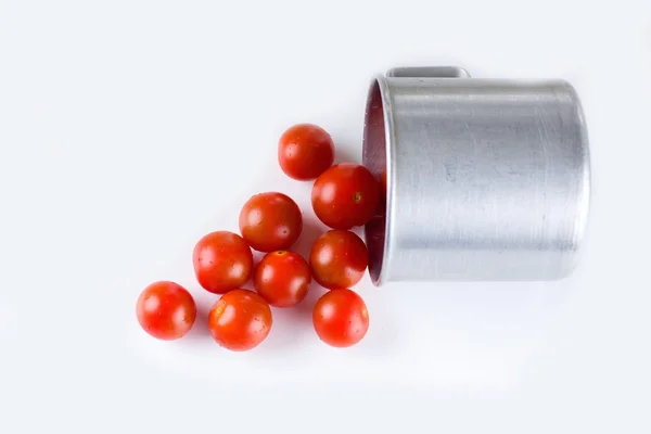 Tomates rojos cereza con gotas de agua derramadas de taza de aluminio —  Fotos de Stock