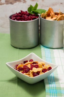 Mısır gevreği yeşil kumaş üzerine bir kase kırmızı çilek ile