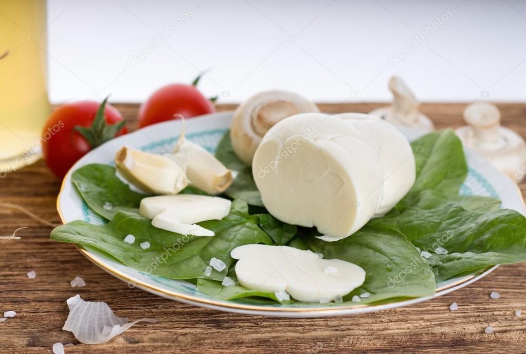 Traditional slovak cheese on plate with baby spinach leaves