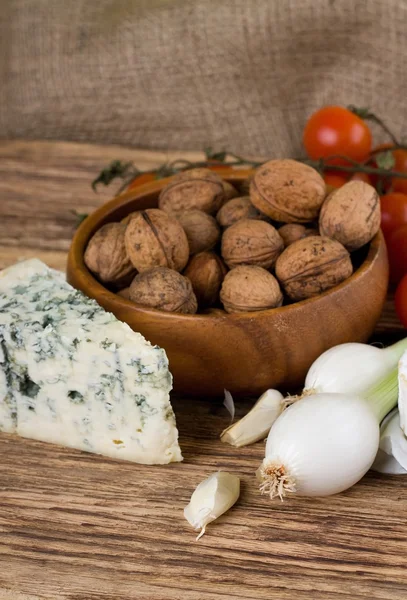 Весенний лук и датский синий сыр перед грецкими орехами — стоковое фото