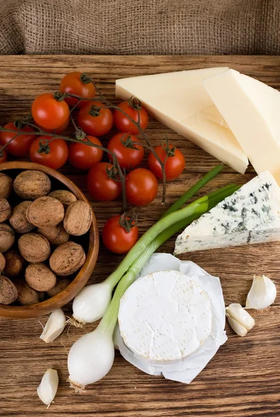 Vista superior em vários tipos de queijo e vegetais — Fotografia de Stock