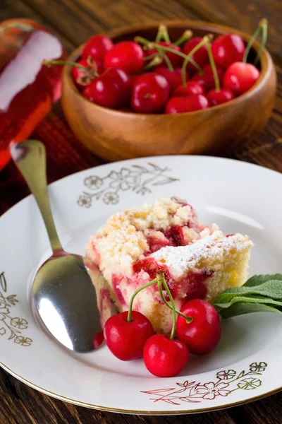 Три вишни перед пирогом на белой тарелке — стоковое фото