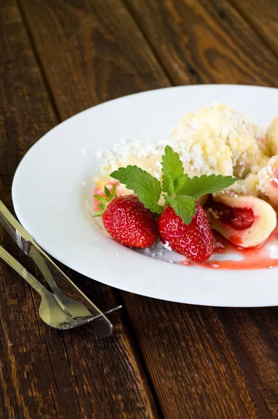 Dos fresas con melisa en plato con albóndigas de frutas —  Fotos de Stock