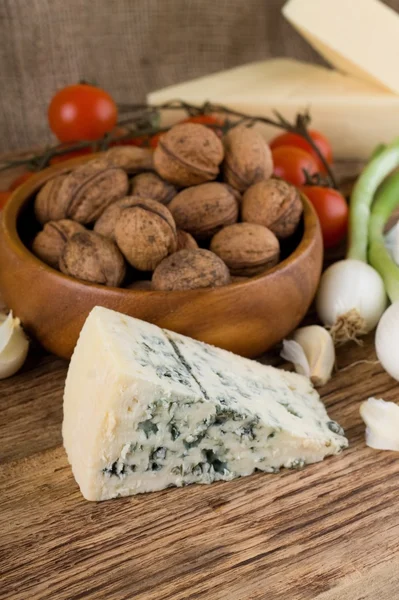 Big portion of niva cheese in front of various vegetable — Stockfoto