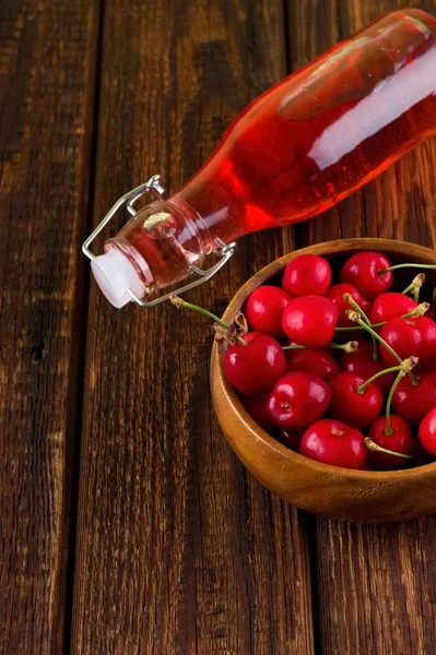 Ciotola di legno piena di ciliegie e limonata rossa — Foto Stock