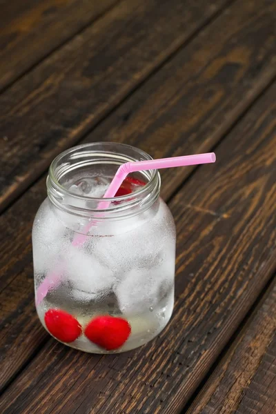 Kaltes Kirschgetränk im Glas auf Holzbrett — Stockfoto