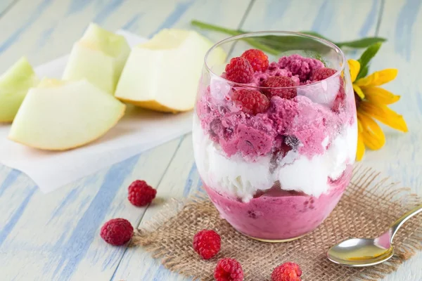 Glass cup full of fruit ice cream and raspberries around — Stock Photo, Image