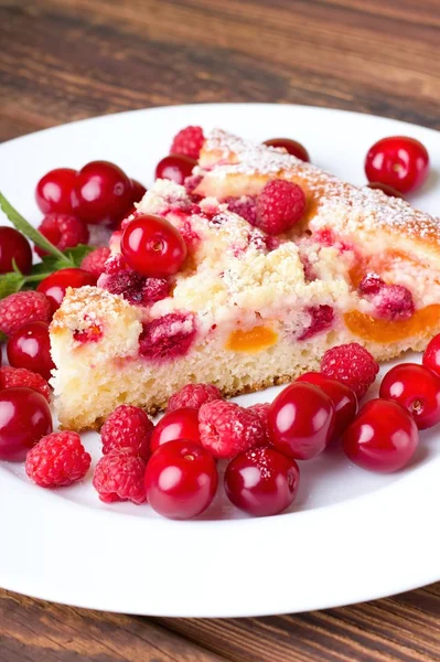 Single slice of fruit pie and several berries around — Stock Photo, Image