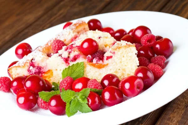 Фруктовый пирог и вишня с малиной на белой тарелке — стоковое фото