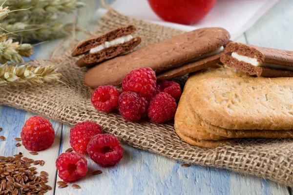 Verschillende frambozen naast creame koekjes — Stockfoto