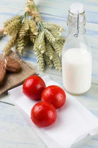Drie rode tomaten en glas melk — Stockfoto