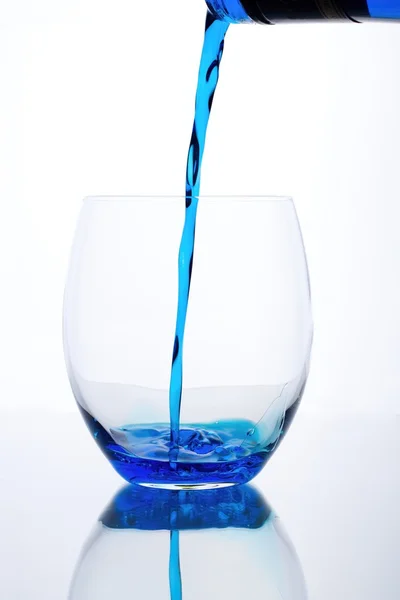Blue drink is flowed into a glass — Stock Photo, Image