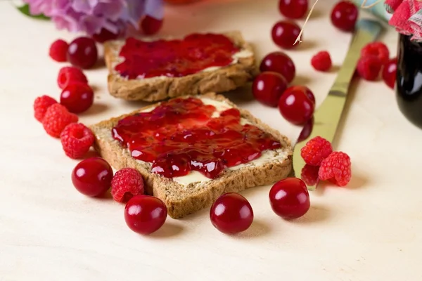 Several berries around toasts with marmalade — Stock Photo, Image
