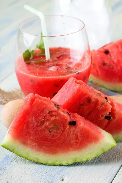 Couple of melon slices in front of fruit smoothie — Stock Photo, Image