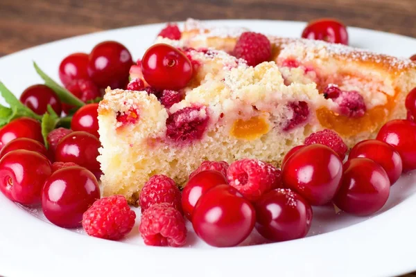 Детальный обзор на ломтик фруктового пирога с ягодами вокруг — стоковое фото