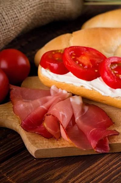 Rebanada de jamón ahumado delante de la baguette con casa de campo — Foto de Stock