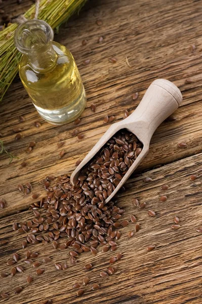Пролитые семена льна из деревянной ложки на старом столе — стоковое фото