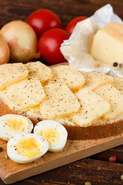 Buttered bread with slices of aromatic cheese and pepper — Stock Photo, Image