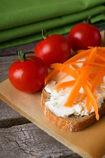 Slice of bread with fresh cheese and carrot shavings — Stock Photo, Image