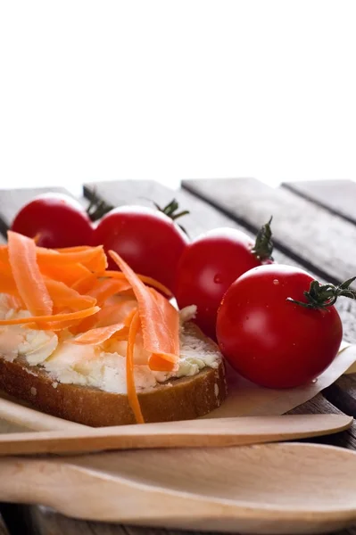 Pan con queso y zanahoria sobre tabla de madera — Foto de Stock