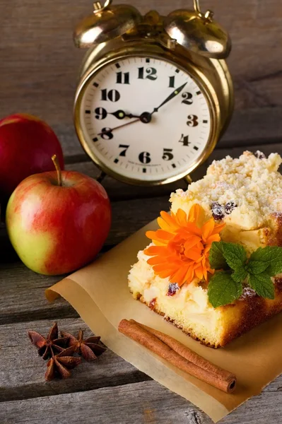 Apple cake with brass alarm clock and spice