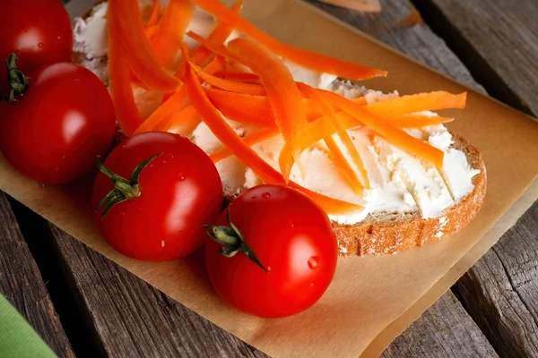 Red cherry tomatoes in front of bread with cottage — Stock Photo, Image