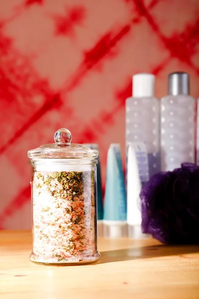 Bath salt in glass jar in front of other accessories — Stock Photo, Image