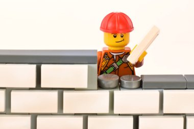 Duvarcı işgali için editoryal illüstrasyon plastik lego minyatür oyuncağı duvar binası.