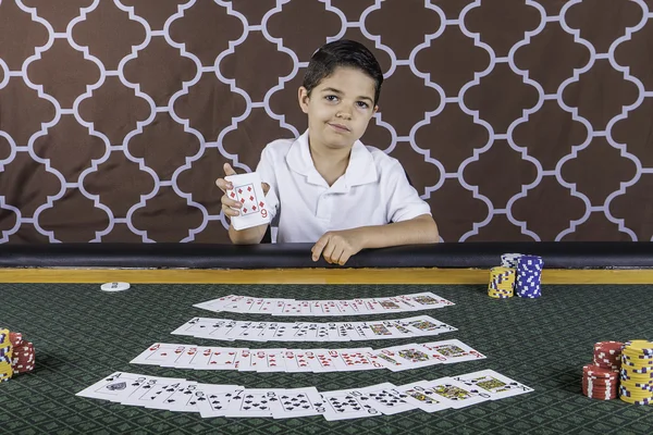 A young boy playing poker at a table