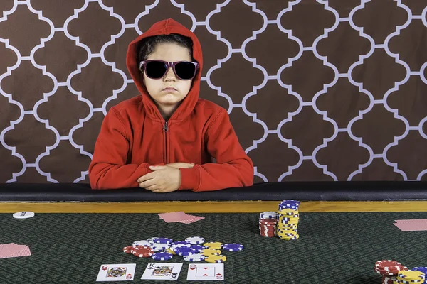 A young boy playing poker at a table — Stock Photo, Image