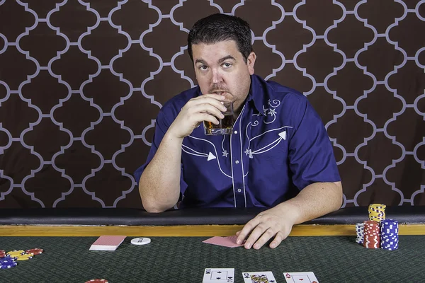 Un hombre jugando al póquer sentado en una mesa —  Fotos de Stock