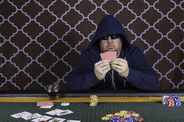 Un hombre jugando al póquer sentado en una mesa —  Fotos de Stock