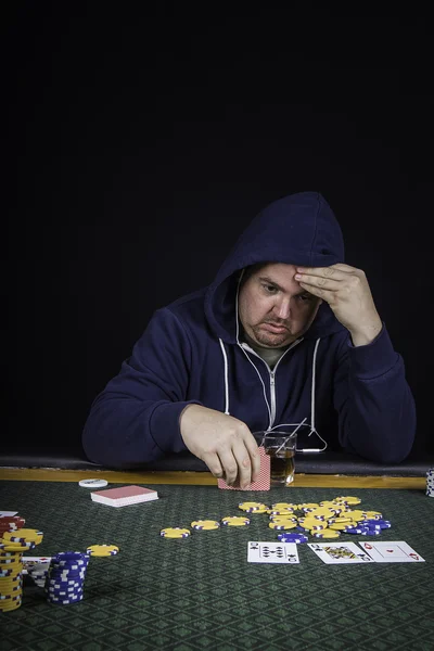 Un hombre jugando al póquer sentado en una mesa —  Fotos de Stock