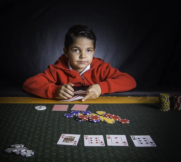 Een jonge jongen spelen van poker in een tabel — Stockfoto