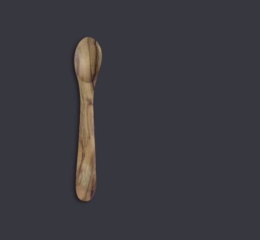 Top up view olive wooden spoon isolated on dark background. suitable for your design element.