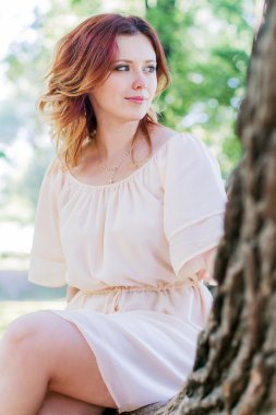 genç kadın bir ağaçta oturuyor