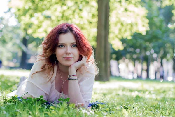 Junge Frau liegt auf dem Gras — Stockfoto